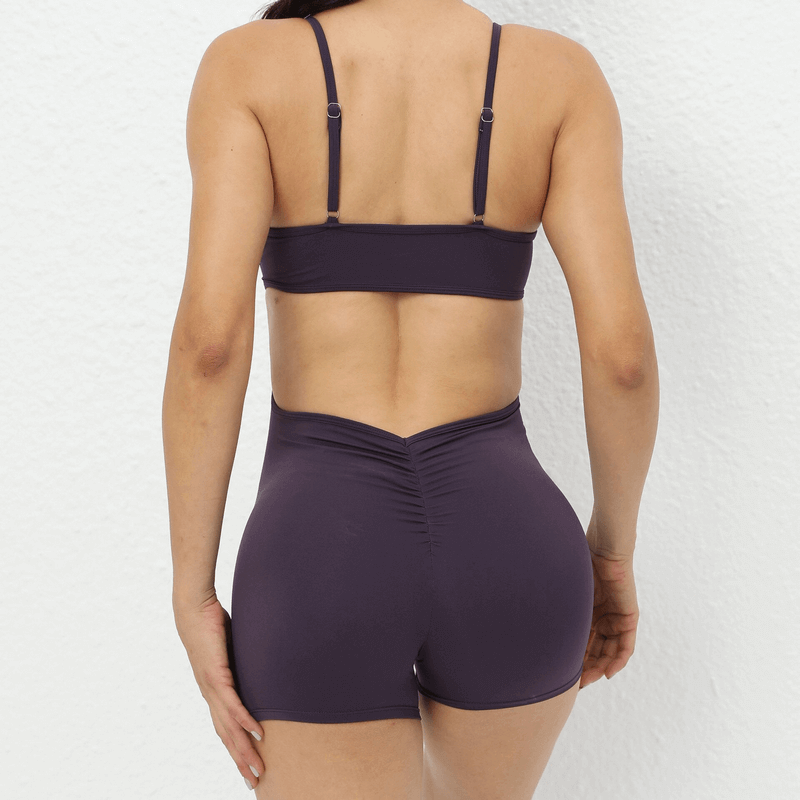 Back view of stylish short jumpsuit with straps for athletic girls, ideal for yoga, in solid color.